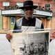 In this, Jan. 13, 2020 file photo, Rev. David Kennedy stands outside the Echo Theater holding a photo of his great uncle’s lynching, in Laurens, S.C. Kennedy has fought for civil rights in South Carolina for decades.